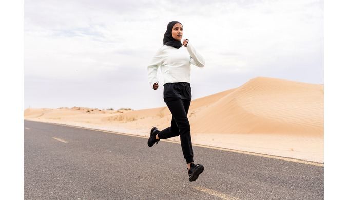 Female athlete running through the desert